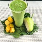 A glass filled with Pear Spinach Mango Smoothie