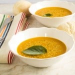 Two white bowls with Spicy Carrot Amaranth soup and garnished