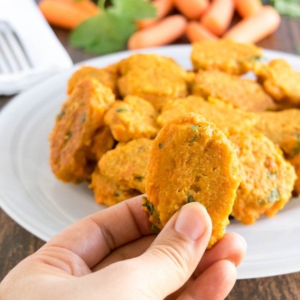 A hand holding skinny carrot fritters