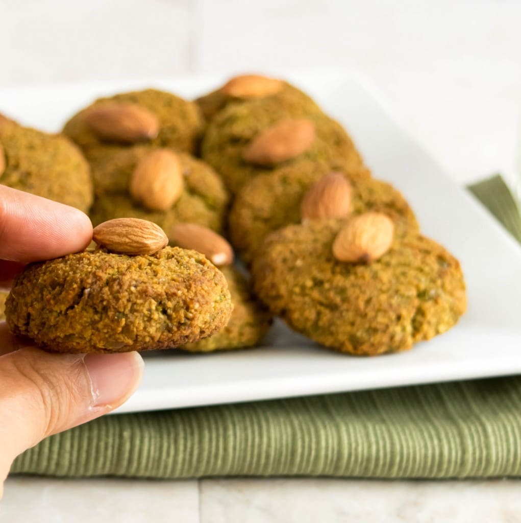 a hand holding one of the green peas cookies.