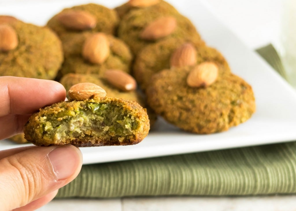 a hand holding a half eaten green peas cookie