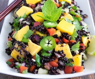 A 45 degree angle view of black rice mango salad