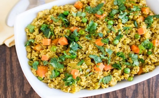 A top view of Masala Oatmeal in a serving dish with garnishes