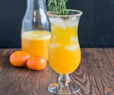A glass filled with orange thyme mocktail