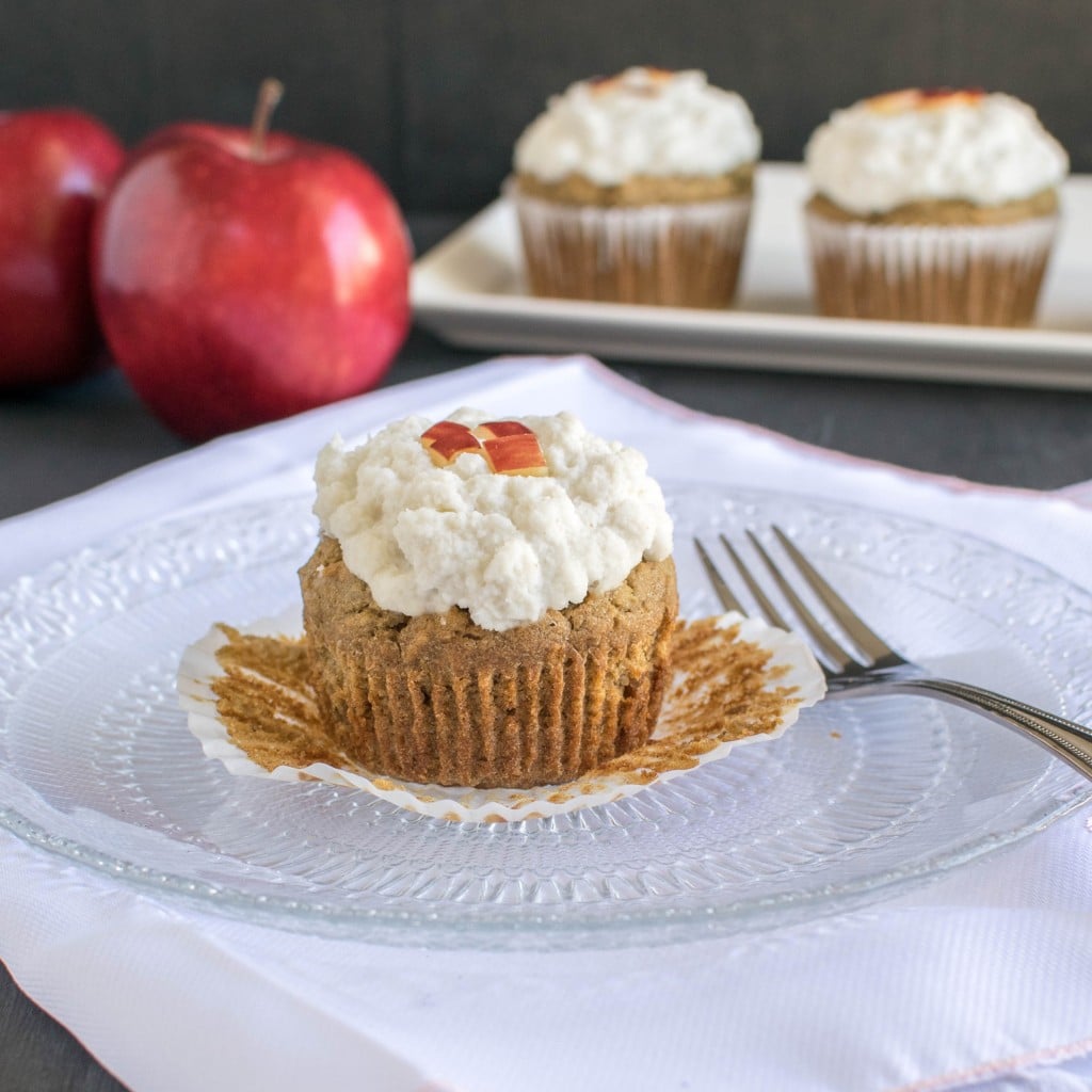  An Apple Oatmeal Cupcakes with Vegan Vanilla Frosting shown on the serving plate with a fork.