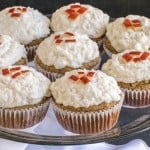 A glass cake stand filled with Apple Oatmeal Cupcakes with Vegan Vanilla Frosting