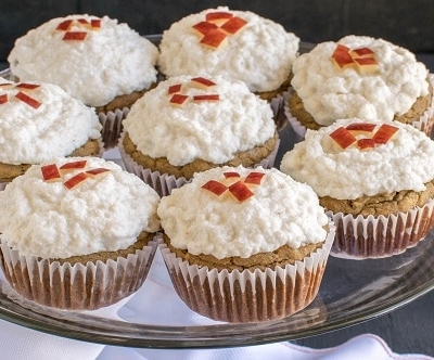 A glass cake stand filled with Apple Oatmeal Cupcakes with Vegan Vanilla Frosting