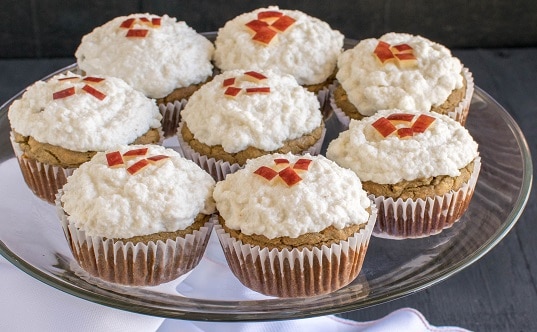 A glass cake stand filled with Apple Oatmeal Cupcakes with Vegan Vanilla Frosting