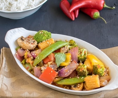 a front view of vegetables in chili garlic sauce served with rice.