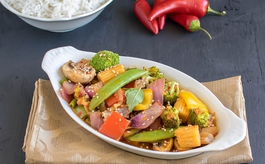 a front view of vegetables in chili garlic sauce served with rice.