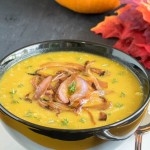 A front view of Apple Pumpkin Soup with fall colored leaves as the prop