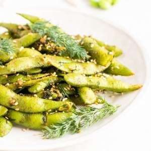 A front view of dill edamame snack in a serving plate