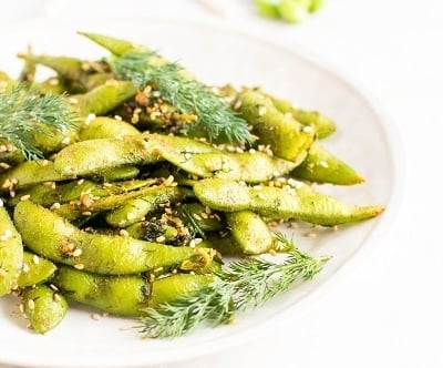 A front view of dill edamame snack in a serving plate