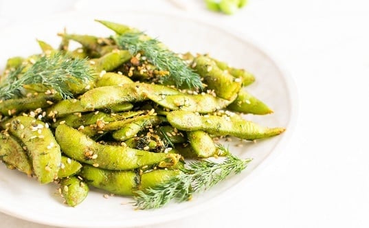 A front view of dill edamame snack in a serving plate