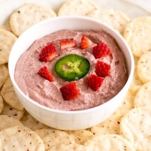 A 45 degree angle view of spicy strawberry walnut dip with crackers