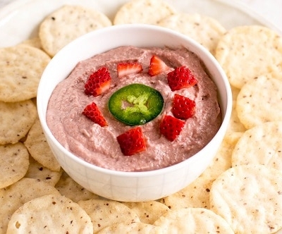 A 45 degree angle view of spicy strawberry walnut dip with crackers