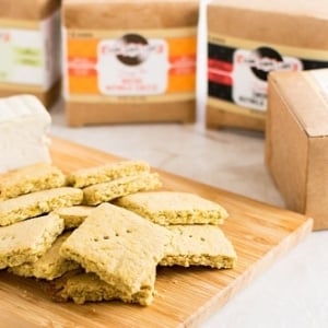 A wooden board filled with Vegan Cheese Turmeric Oats Crackers
