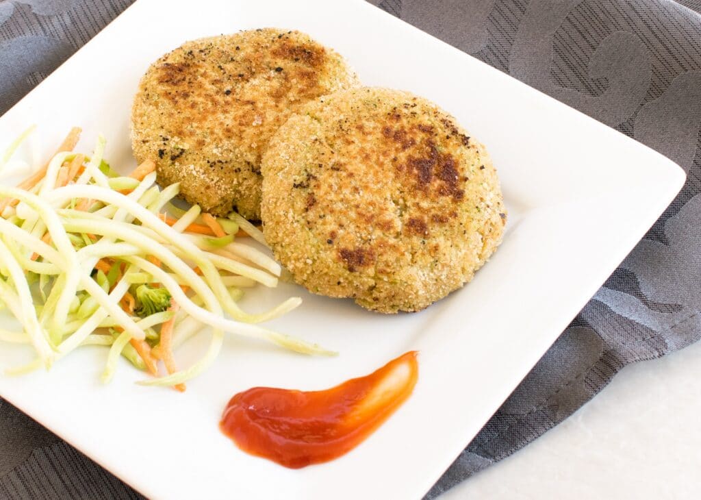 Top view of Lentil Broccoli Breakfast Cutlets on a white serving plate with a side salad