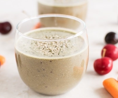 A glass filled with Cherry Carrot Smoothie is shown with the ingredients as the prop