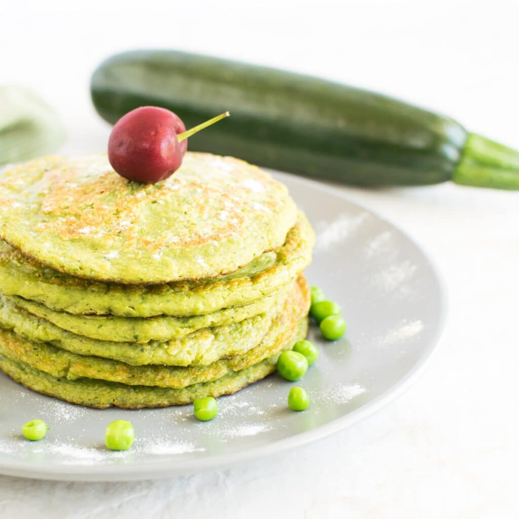 A stack of Green Peas Zucchini Pancakes on a grey plate 