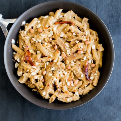 Top view of seitan and pasta in spicy peanut sauce in a pan