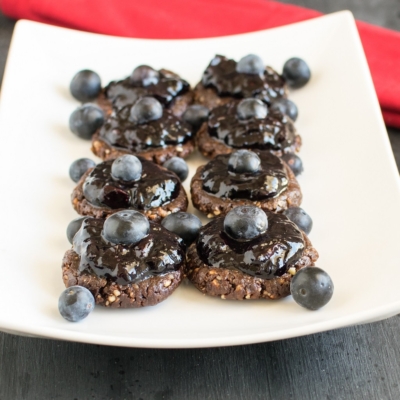A 45 degree angle view of no bake chocolate walnut cookies with blueberry jam frosting