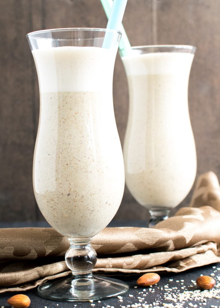 two tall glasses filled with almond butter hemp smoothie