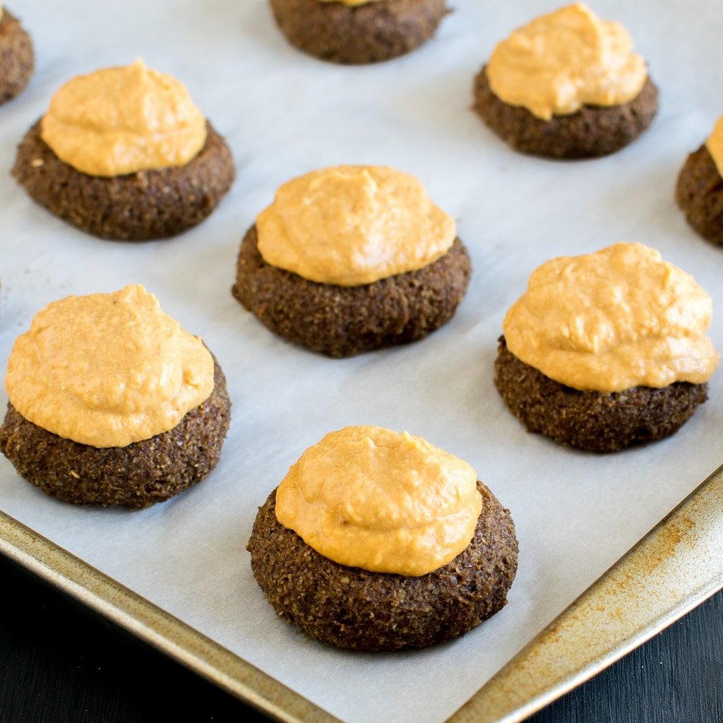 Cookies with  pumpkin cheesecake frosting on a cookie sheet 