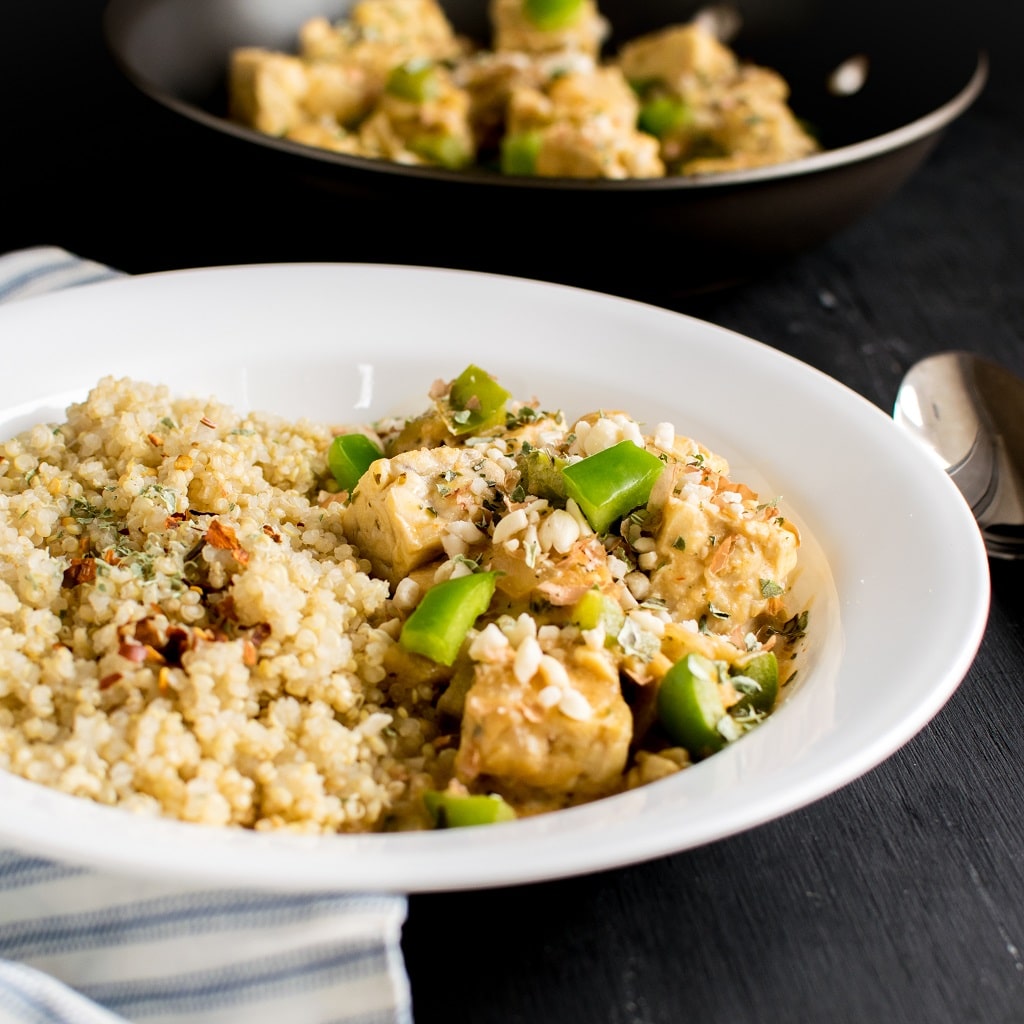 A plated One Pot Peanut Butter Tempeh Curry paired with quinoa
