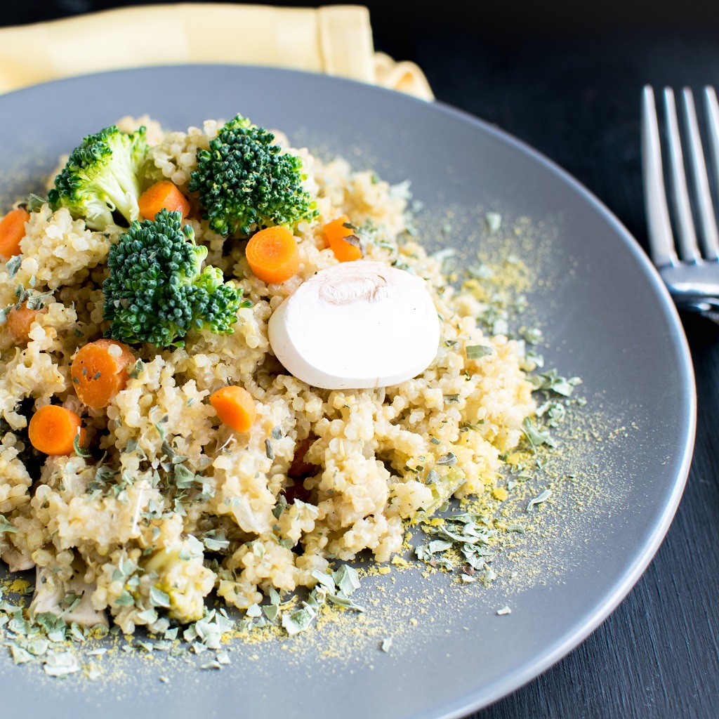 Pressure Cooker Vegan Cheese vegetable Quinoa is shown on a grey plate with a fork and a table cloth as the props | kiipfit.com