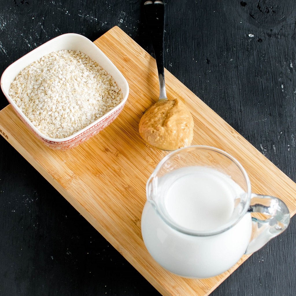 The raw ingredients of Peanut Butter Quinoa Flake Porridge on a wooden board is shown in this image | kiipfit.com