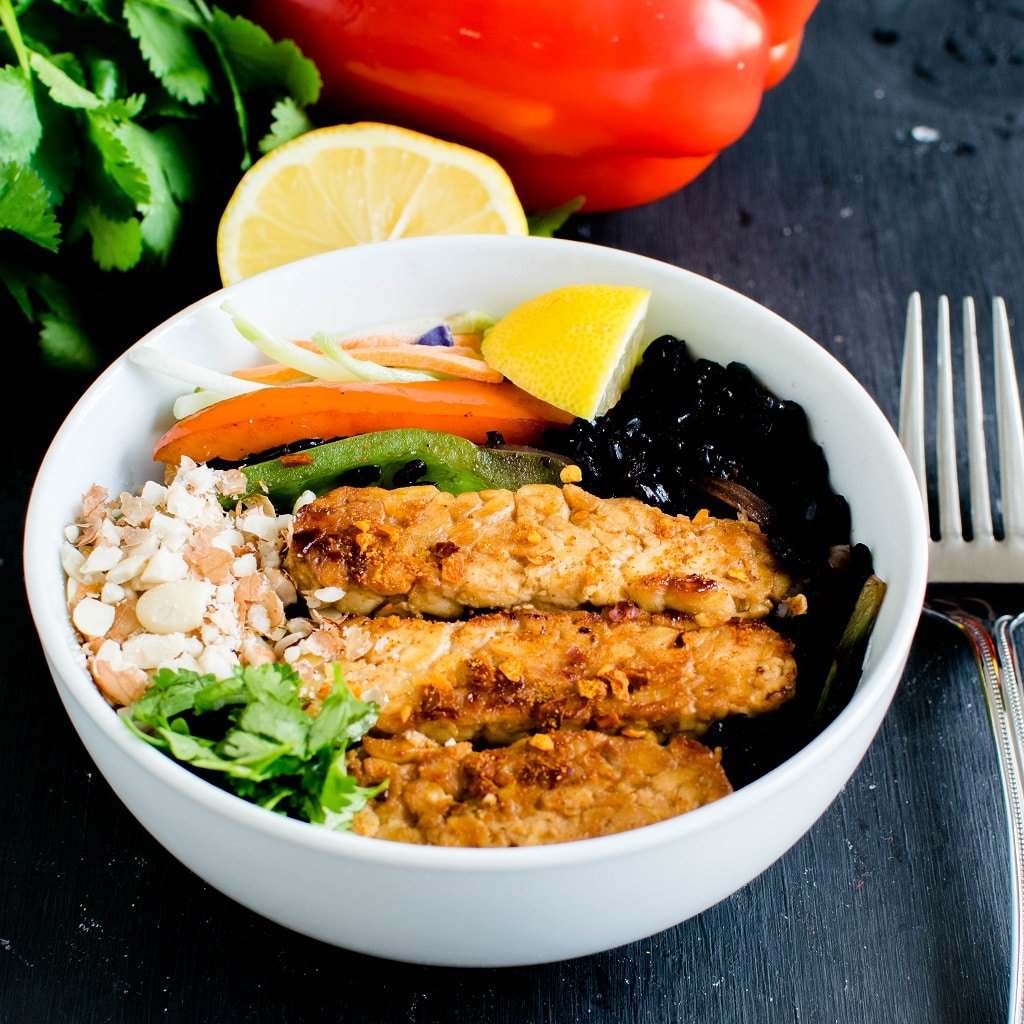 A complete recipe of black rice sriracha tempeh bowl in one serving bowl is shown in this image. The raw ingredients has been used as props in this picture | kiipfit.com