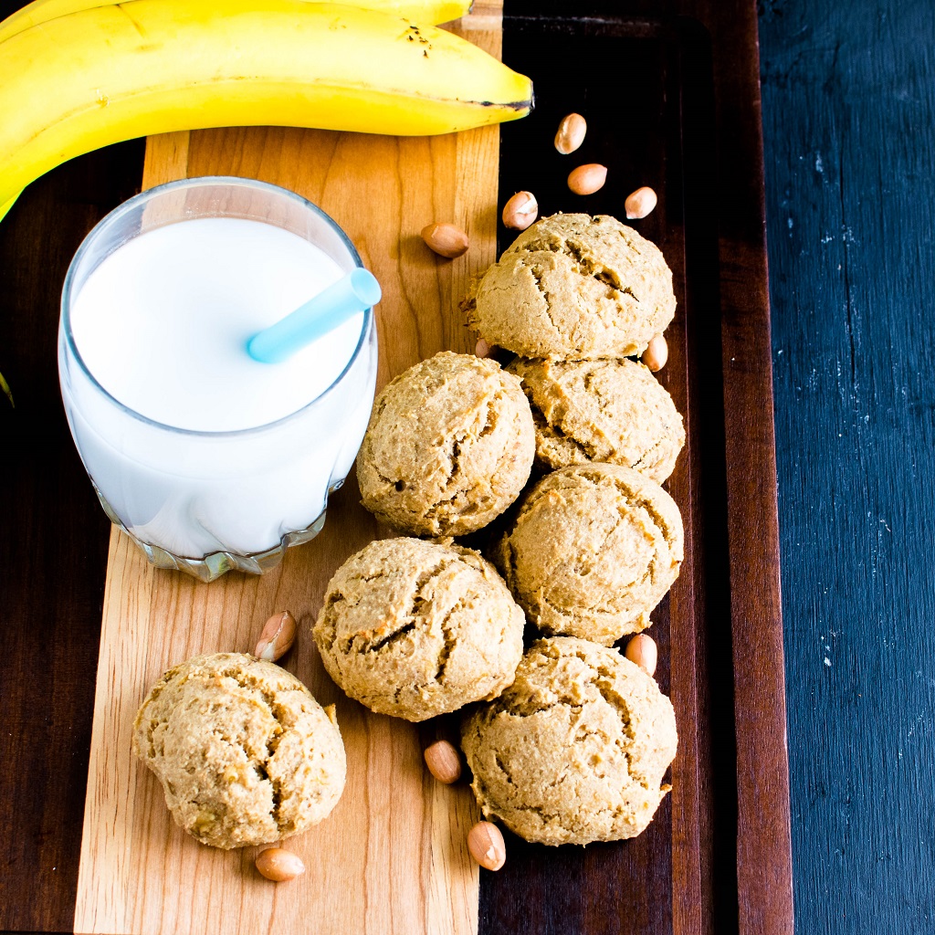 A wooden board stacked with Peanut Butter Banana Amarnth Cokies along with a glass of milk is shown in this image | kiipfit.com