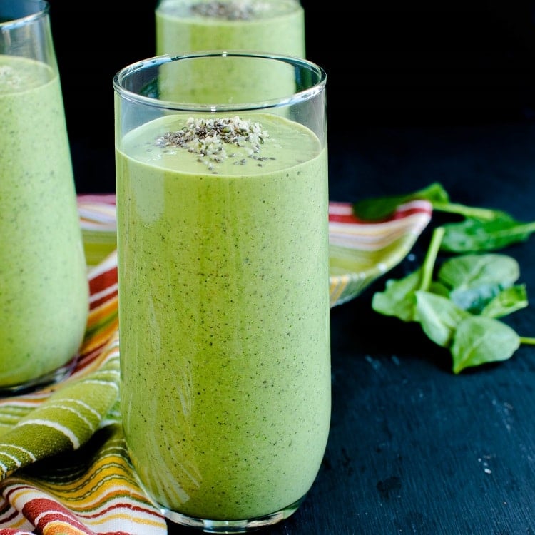 A close of a tall glass filled with Chia Hemp Green Smoothie is shown in this image.