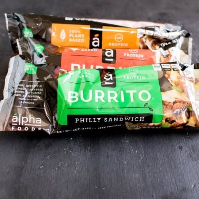 A stack of packed Alpha Burritos are shown in this image