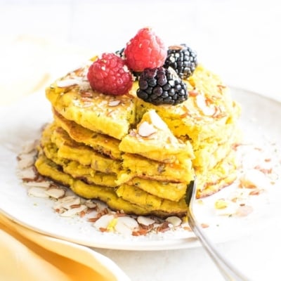 A fork cutting the pancakes in a triangle pieces is shown in this image