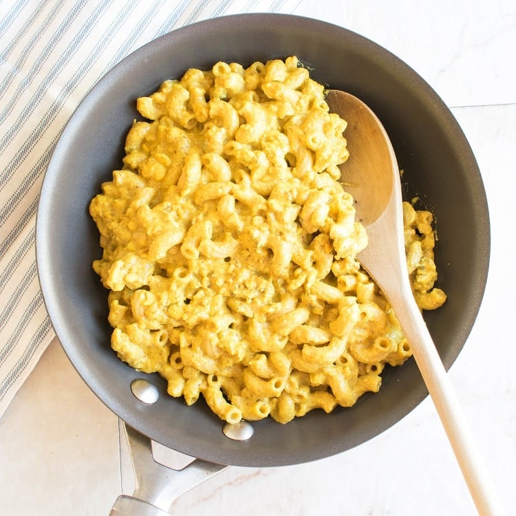 Moroccan Tempeh Mac and Cheese in a pan with a wooden spatula