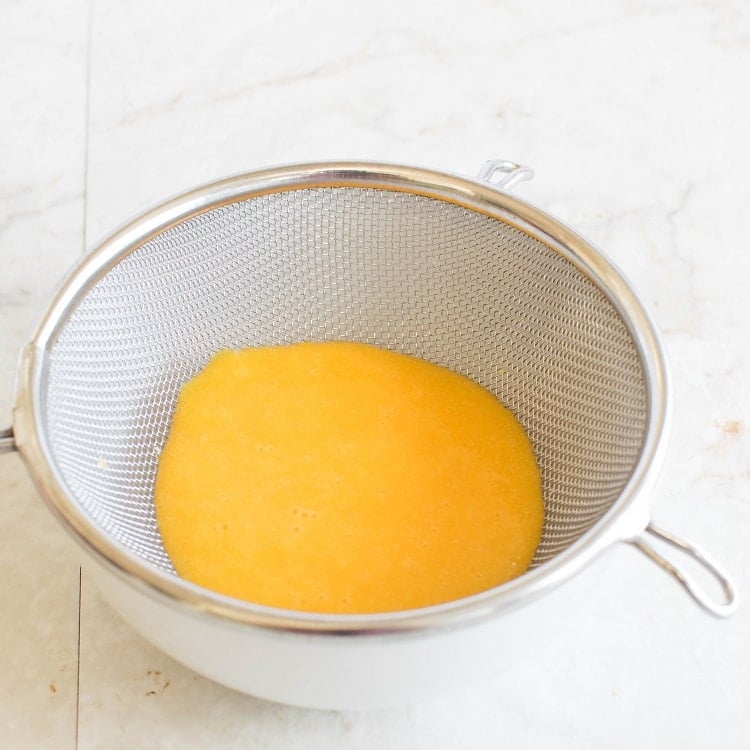 Fresh squeezed Orange juice in a strainer.