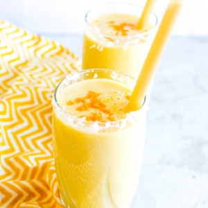 A 45 degree angle of Tropical Coconut Turmeric Smoothie in serving glasses