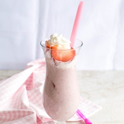 A front view of a glass filled with Vegan Strawberry Shortcake Protein Smoothie