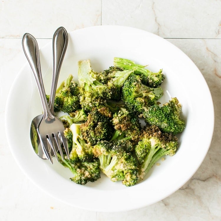 Crispy Broccoli served in a white plate with fork and spoon