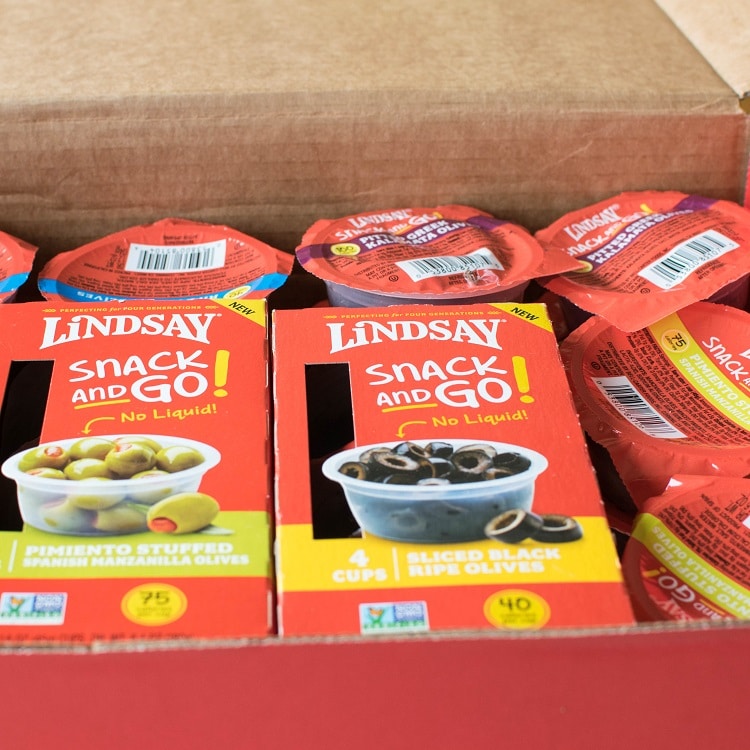 A box full of a variety of Lindsay Snack and Go Olives.