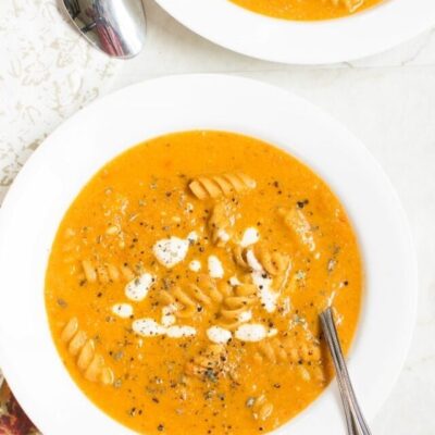 Top view of two serving soup bowls with Roasted Red Pepper Pasta Soup