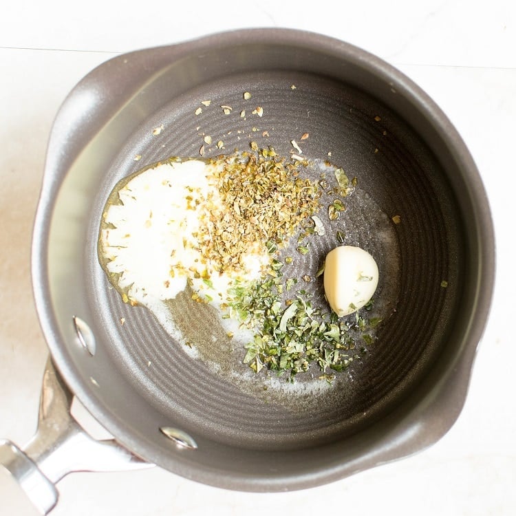 Melting vegan butter, garlic and herbs in a saucepan