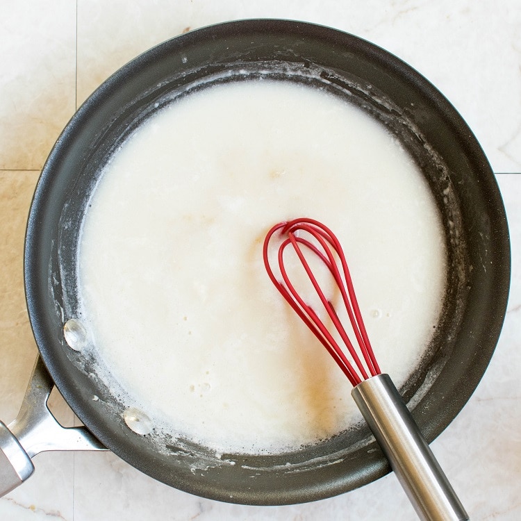 Coconut milk in the nonstick pan with the whisk