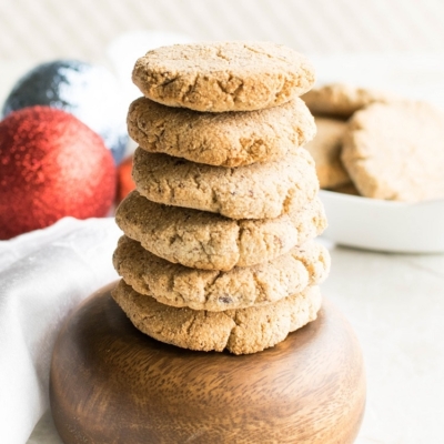 A tall stack of vegan eggnog cookies on a wooden bowl.