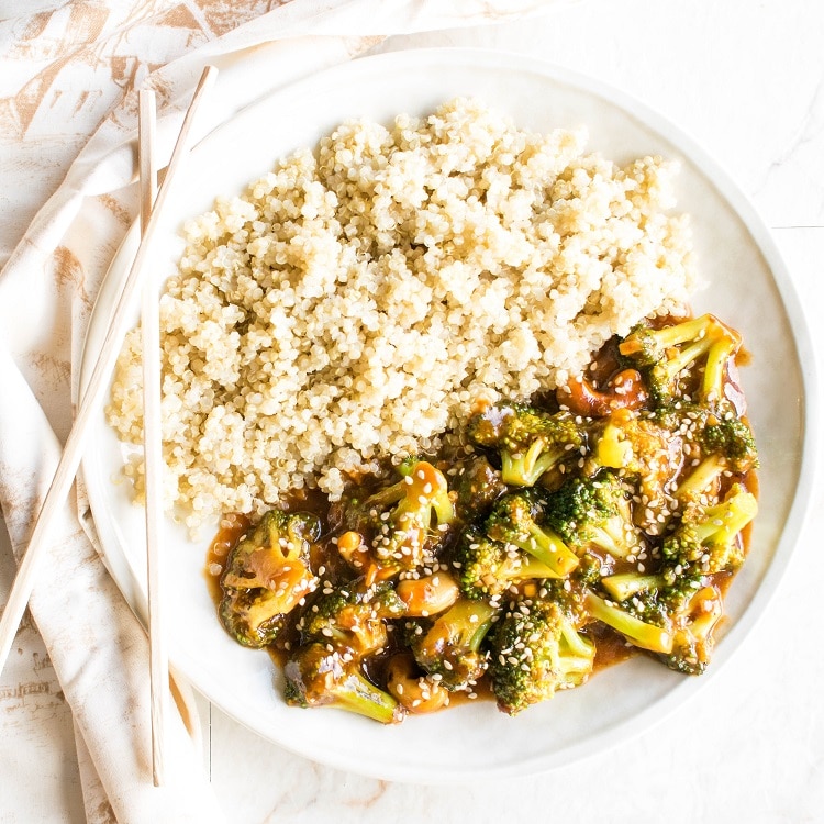 Top view of Spicy Cashew Broccoli Stir Fry in a serving plate with chopsticks as the prop