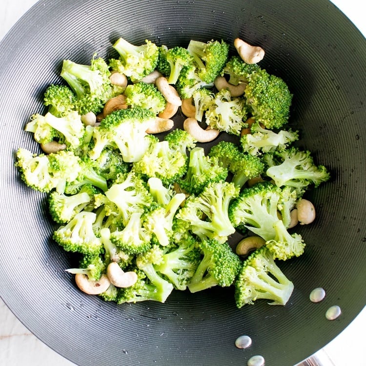 sauteed broccoli florets and cashew nuts in a wok