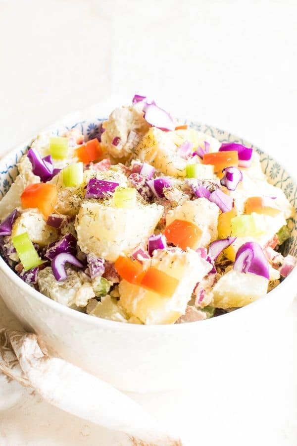A serving bowl heaped with healthy vegan potato salad