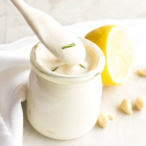 A spoon picking vegan sour cream from the glass jar